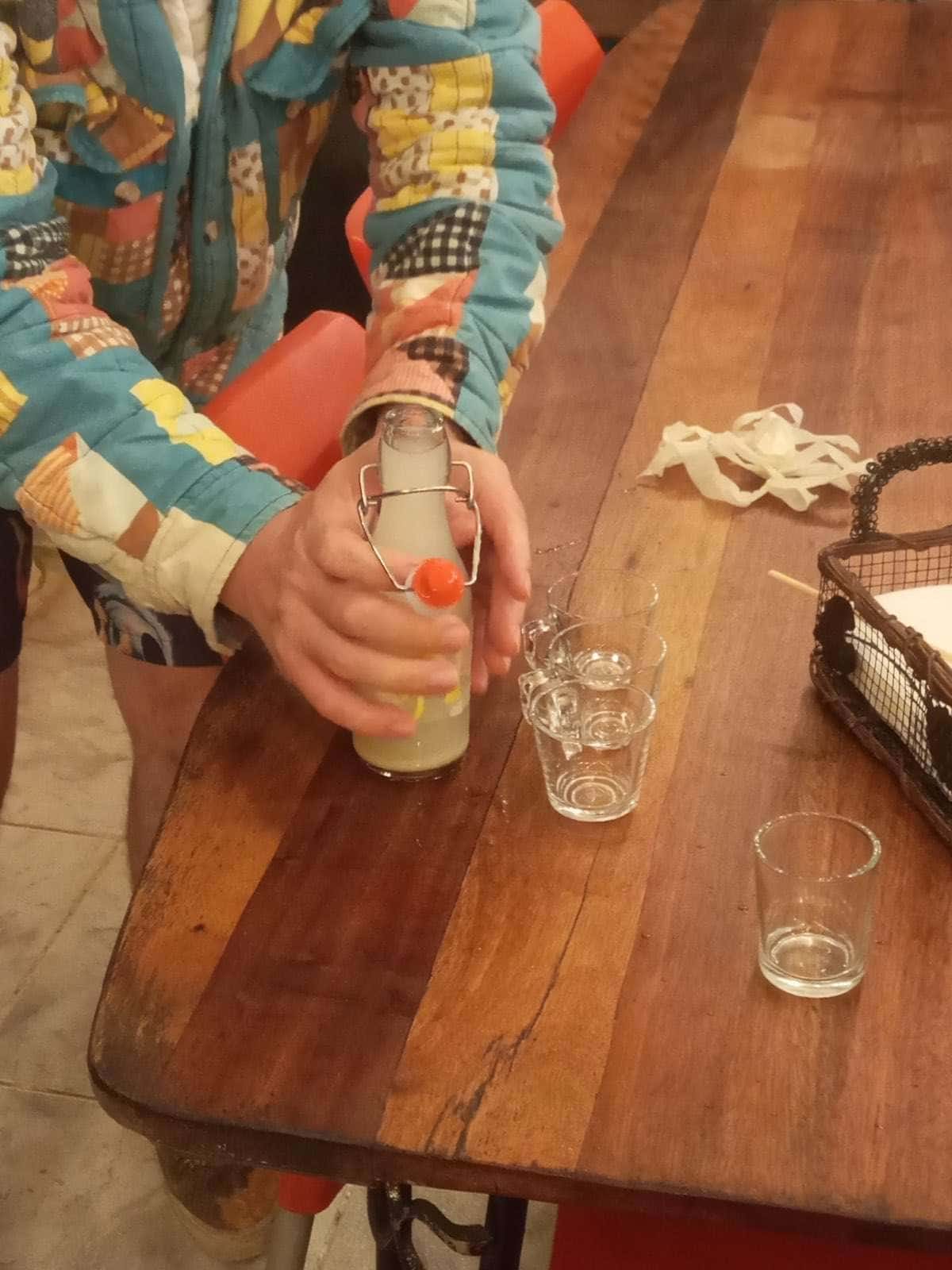 La botella sobre una mesa de madera junto a unos vasos de cata pequeños